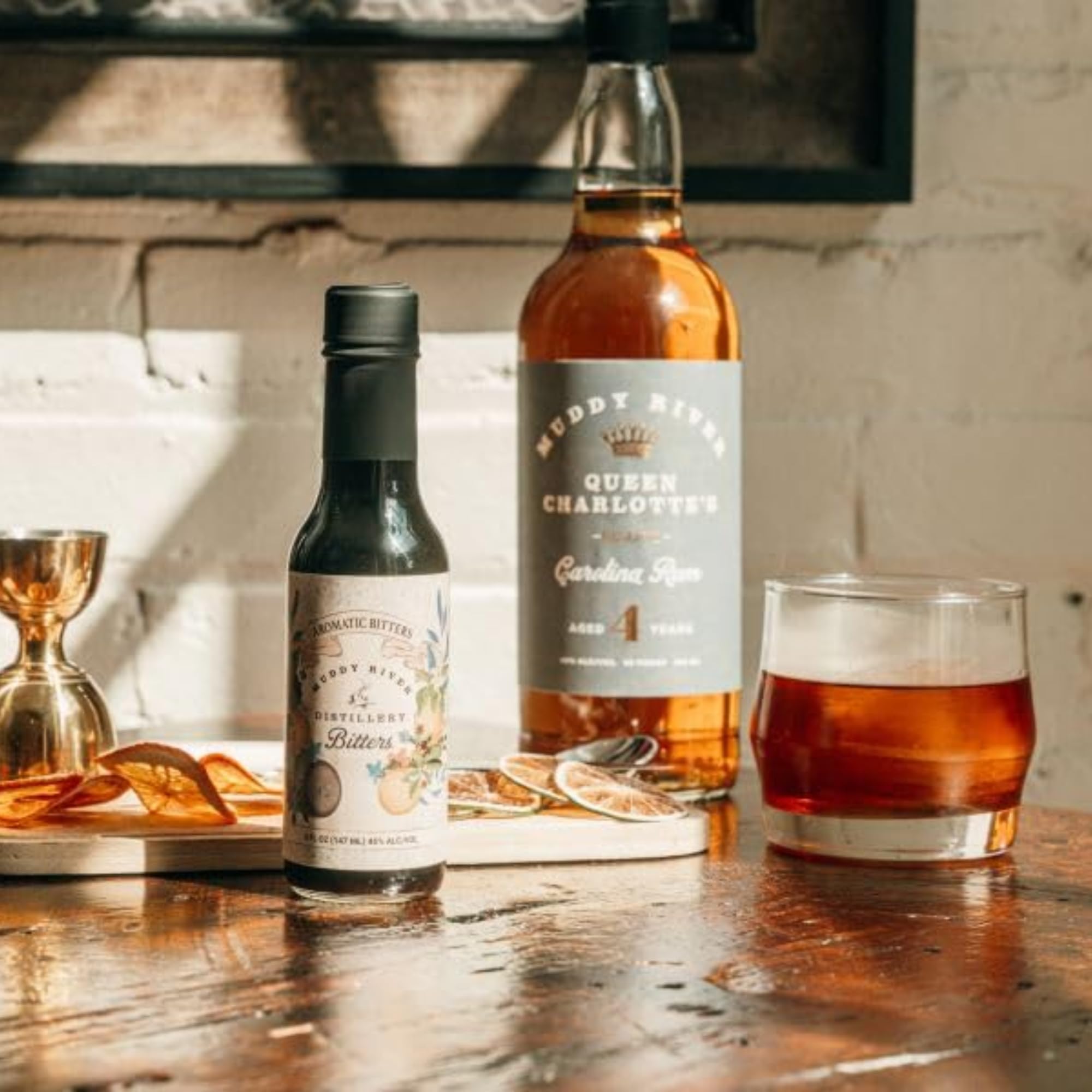 Muddy River Distillery bottle beside an American white oak barrel showing aged complexity