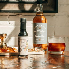 Muddy River Distillery bottle beside an American white oak barrel showing aged complexity