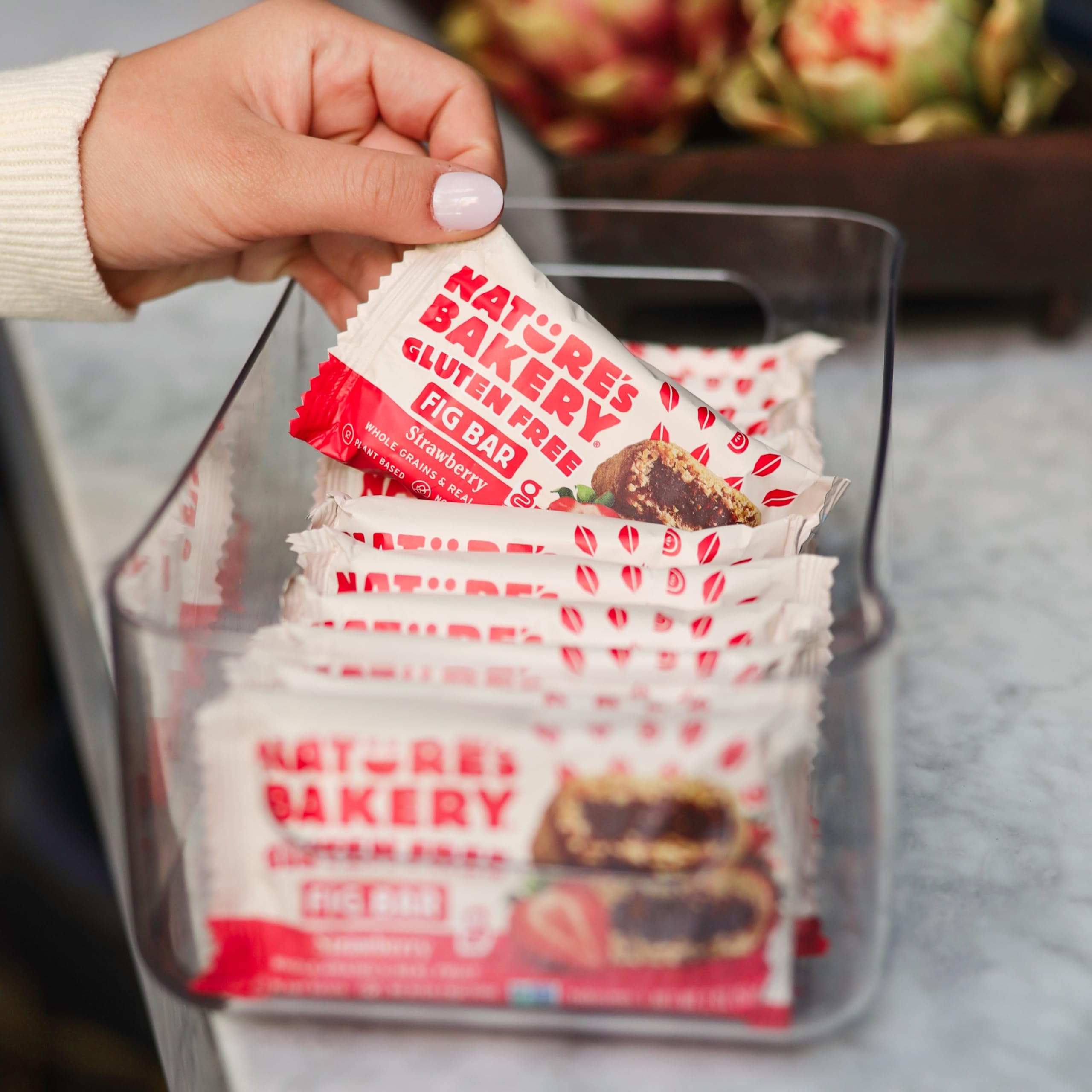 Nature's Bakery bar in hand for size comparison and grab-and-go benefit