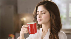 Nescafé pouring hot water into mug with sachet creating instant froth and flavour