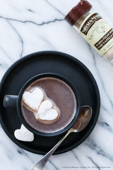 Nielsen-Massey vanilla powder jar opened with visible fine powder, easy-to-scoop benefit