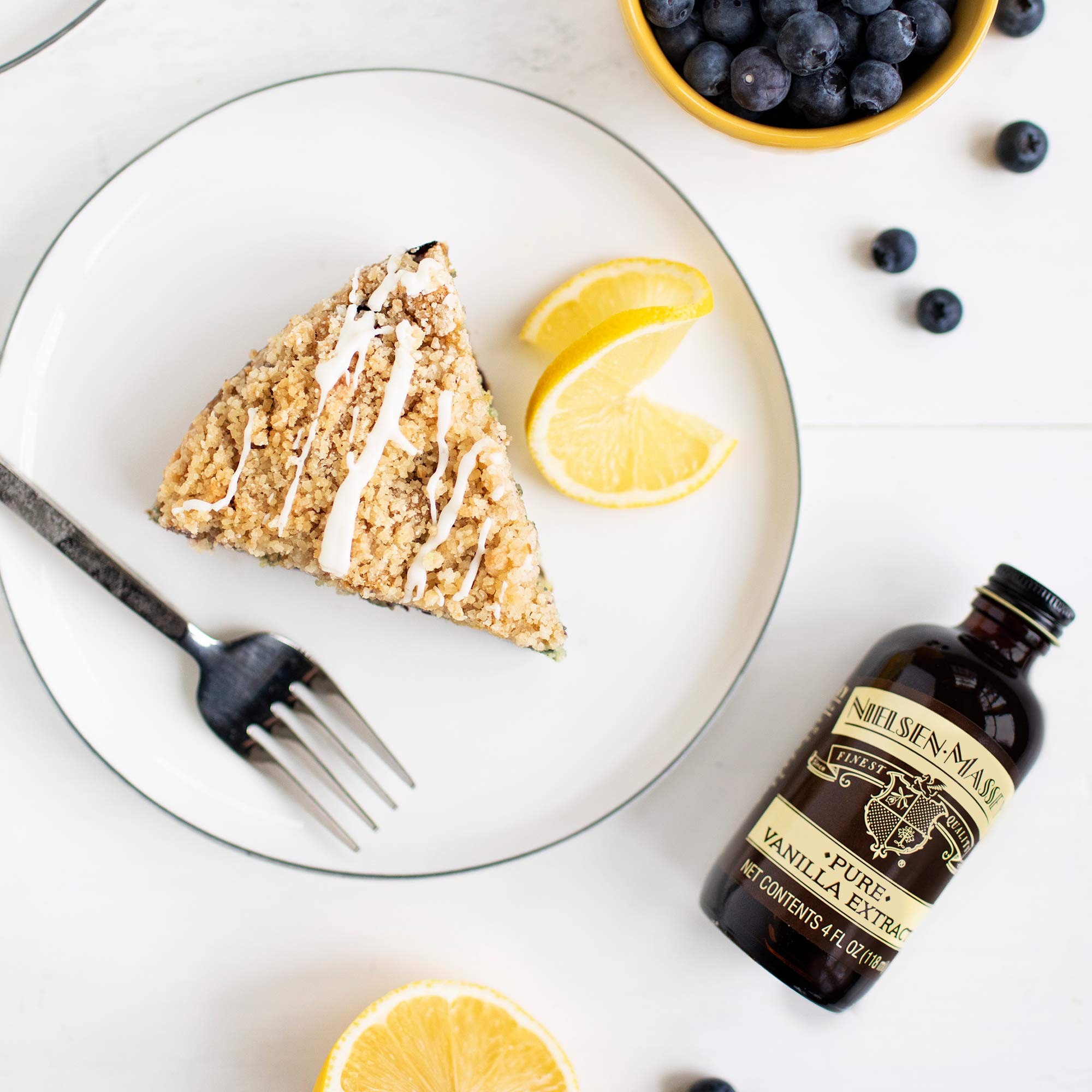 Spoon with Nielsen-Massey vanilla extract demonstrating easy measurement and mixing
