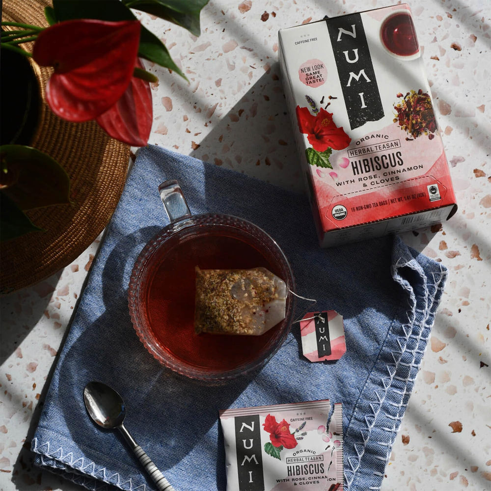 Numi flatlay of hibiscus, rose petals, and spices showing true botanical ingredients