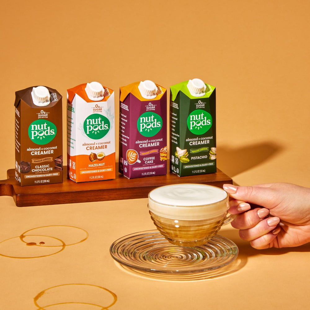 nutpods four-pack beside coffee mug for scale, demonstrates individual 11.2oz shelf-stable cartons