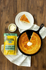 Old School Brand cornmeal in a wooden bowl ready to measure with a spoon for baking ease