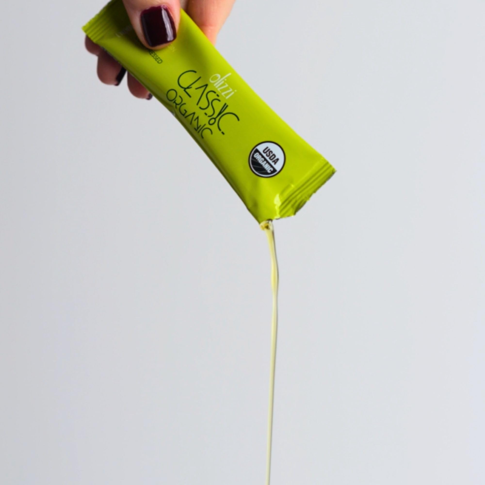 Olizzi packet used to dress a salad outdoors, ideal for on‑the‑go meals