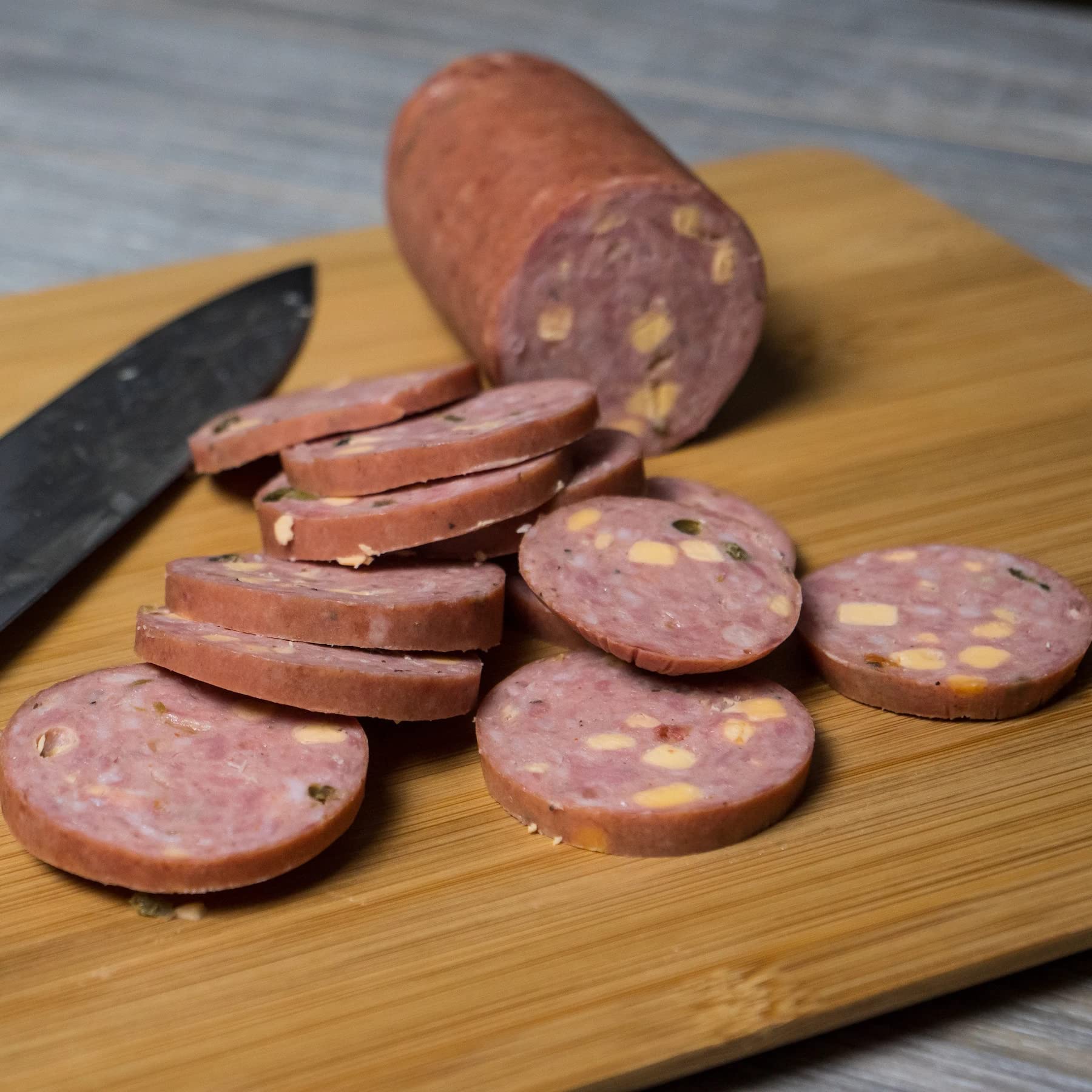Pepper Joe's sliced on a charcuterie board with crackers, ideal for entertaining