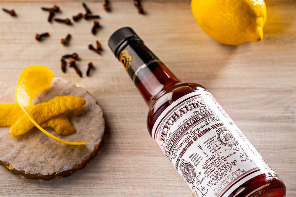 Peychaud's bottle being dashed into cocktail for balanced flavor benefit