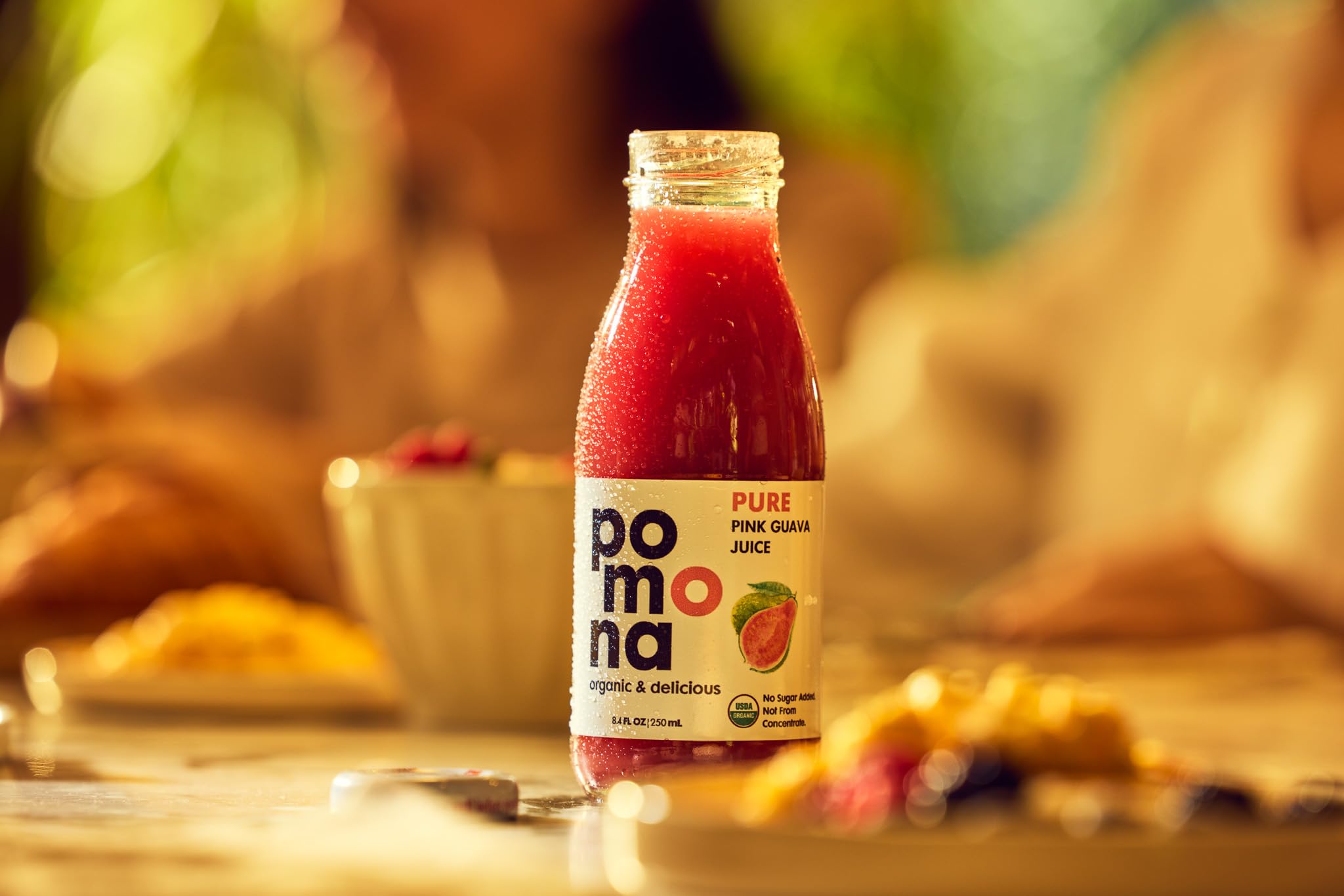 Pomona Organic pouring pink guava juice into glass for ready-to-drink refreshment