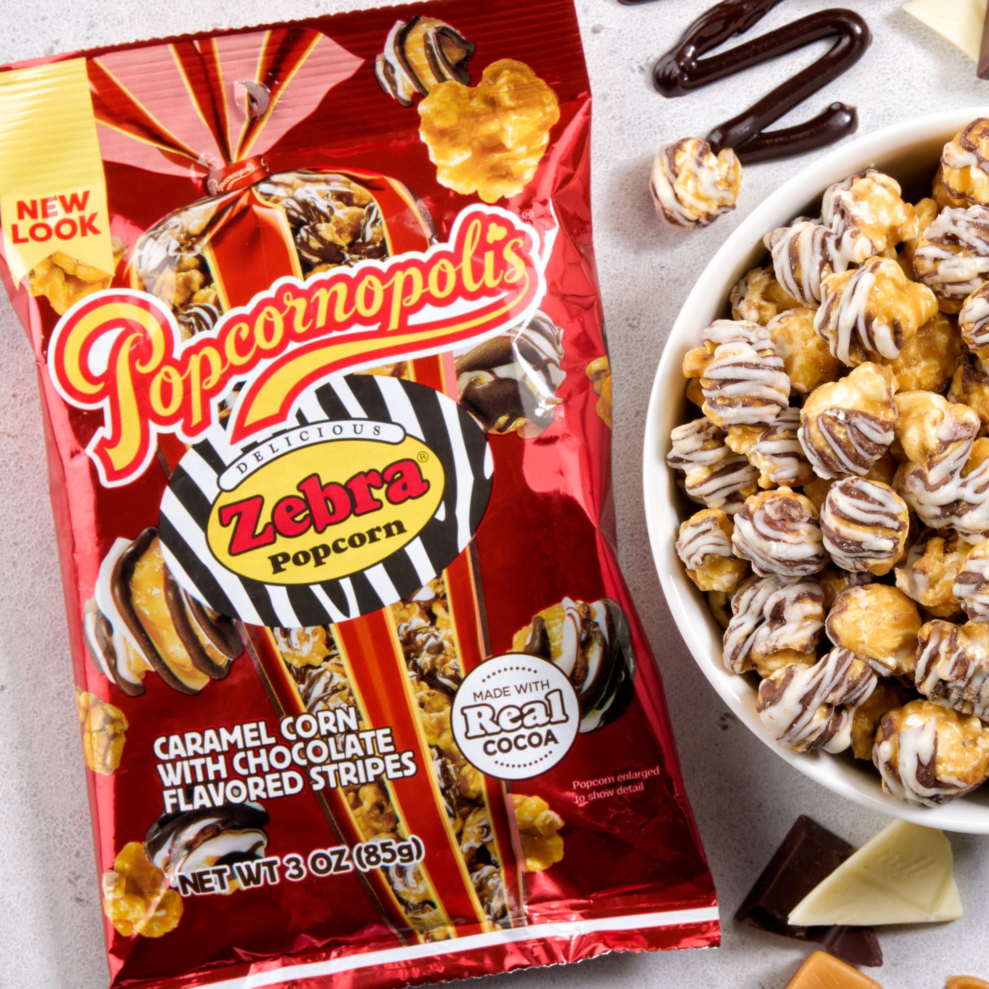 Popcornopolis zebra popcorn held in hand to show single-bag size and portability