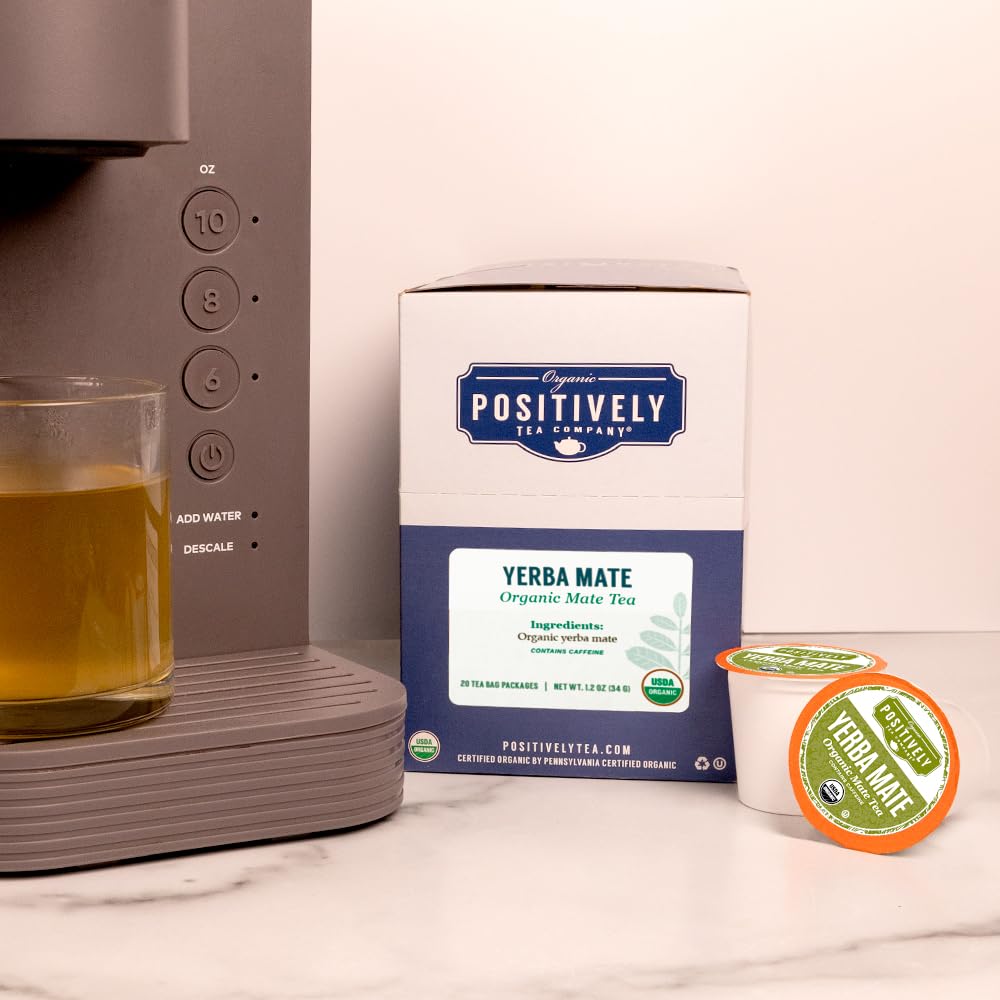 Hand holding Positively Tea pod next to a coin for size and portability context