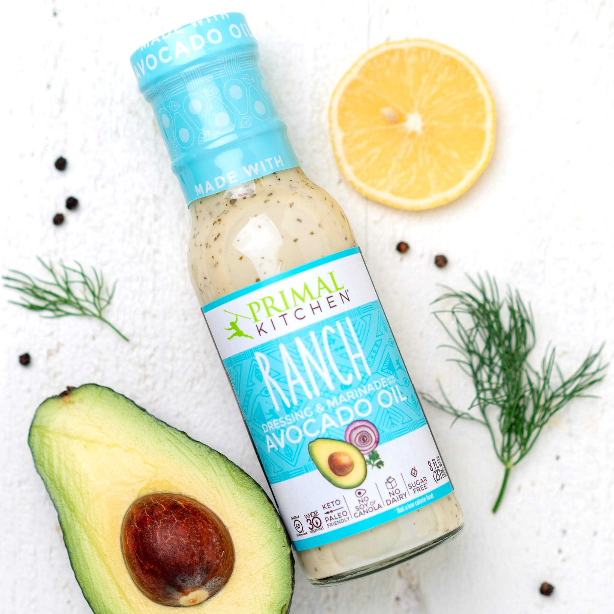 Primal Kitchen Green Goddess bottle angled to show herb-speckled, dairy-free formula