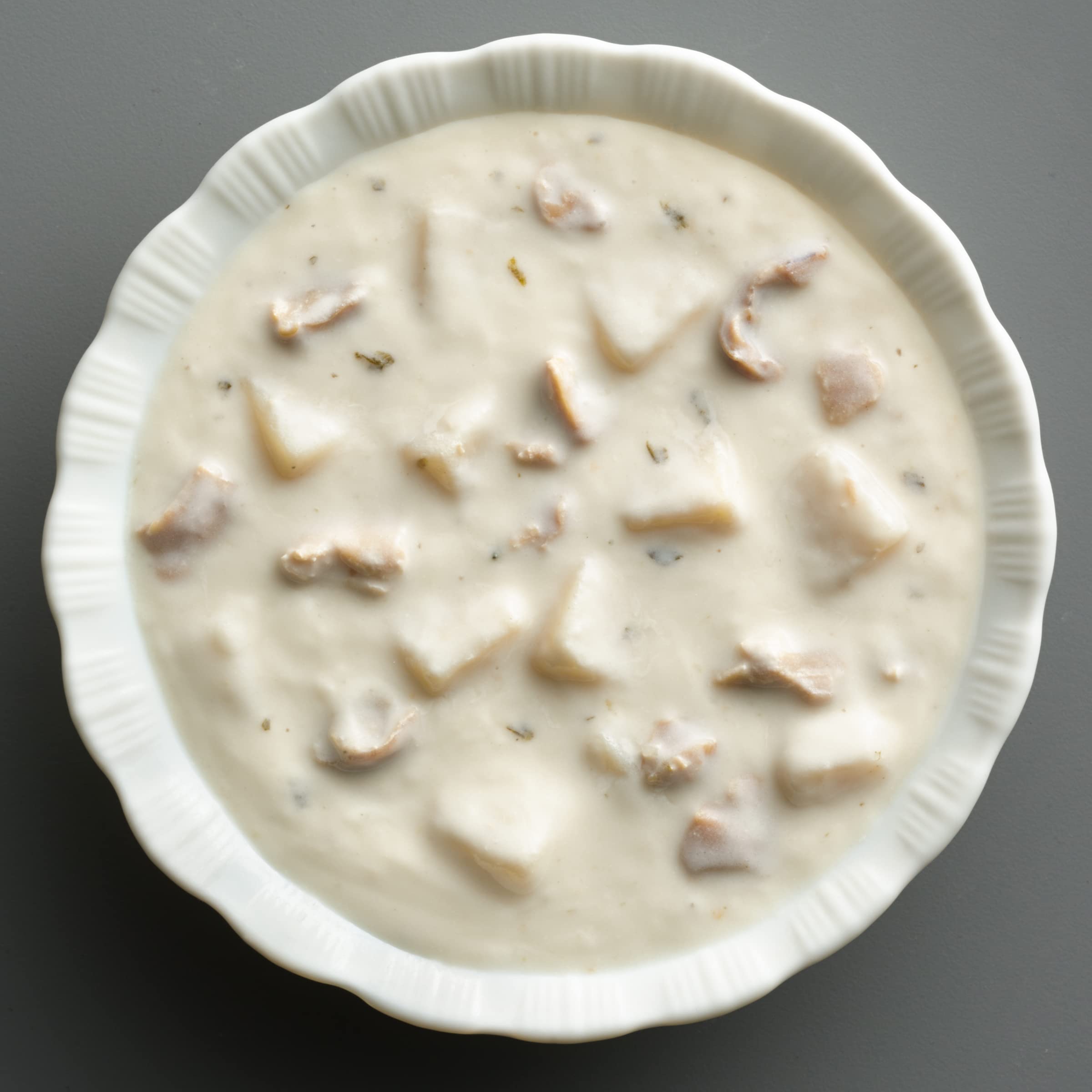 Bowl of Progresso chowder next to crusty bread demonstrating serving idea