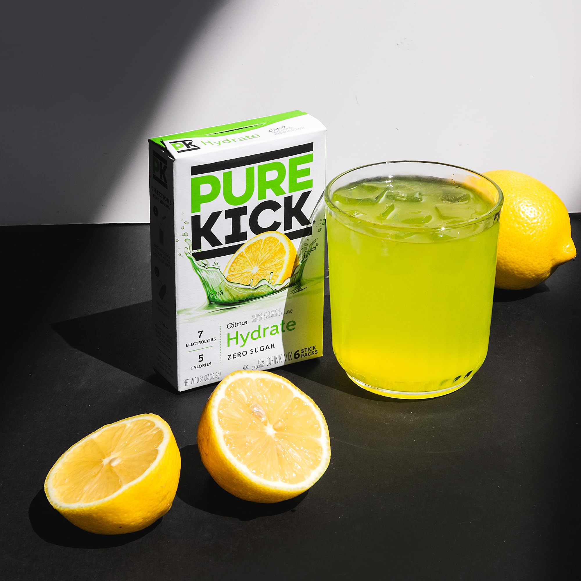PURE KICK packets beside a standard water bottle for scale and convenience