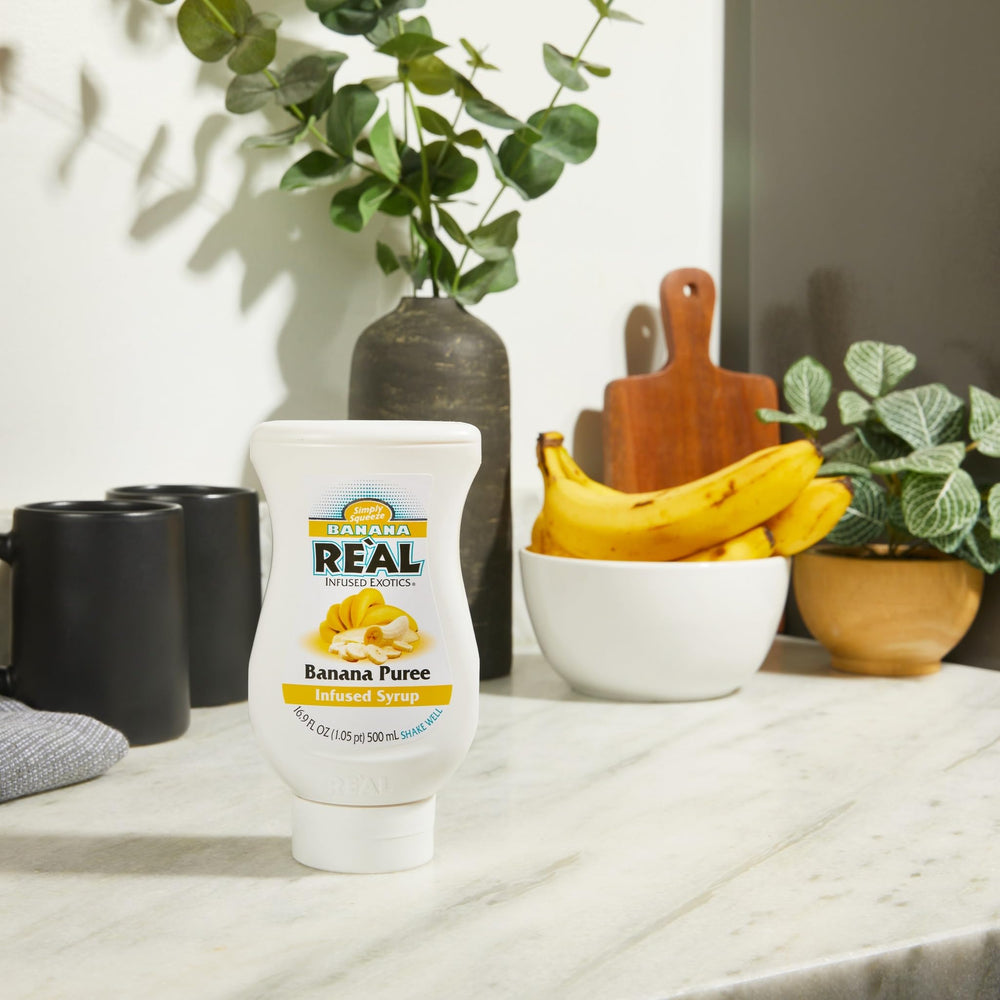 Reàl Infused Exotics being squeezed into a cocktail for consistent banana flavor, speeds service