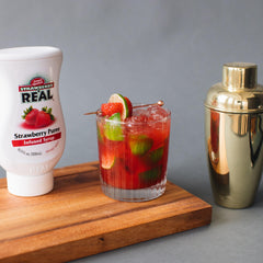 Reàl Infused Exotics strawberry bottle close-up showing label and easy-squeeze cap benefit