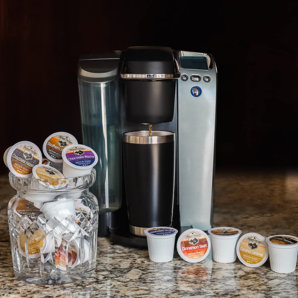 Roast Ridge pod next to a single-serve machine showing scale and fit