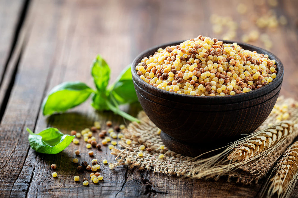 Sanniti fregola on wooden spoon demonstrating firm, separate pearls