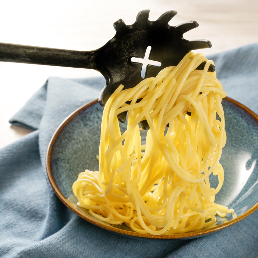 Sanniti spaghetti beside measuring cup for portion and scale guidance