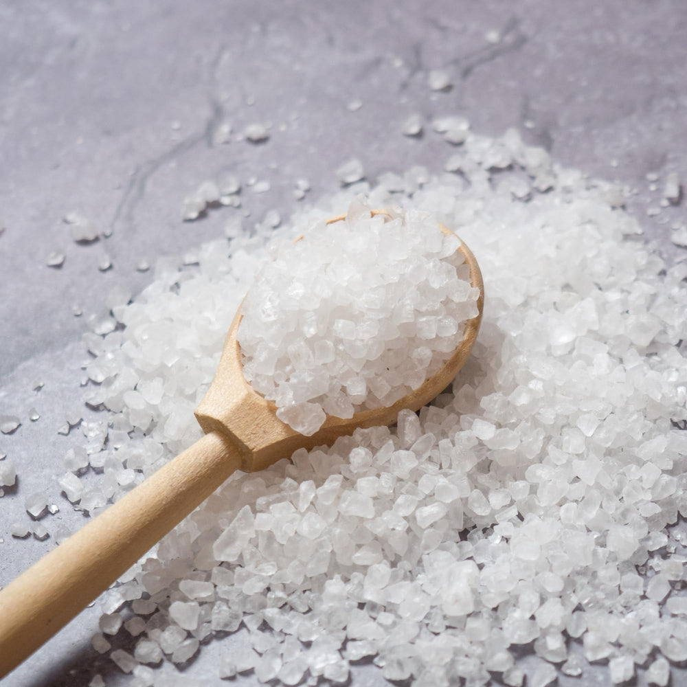 Sanniti spoon heaped with coarse salt illustrating easy finishing and seasoning