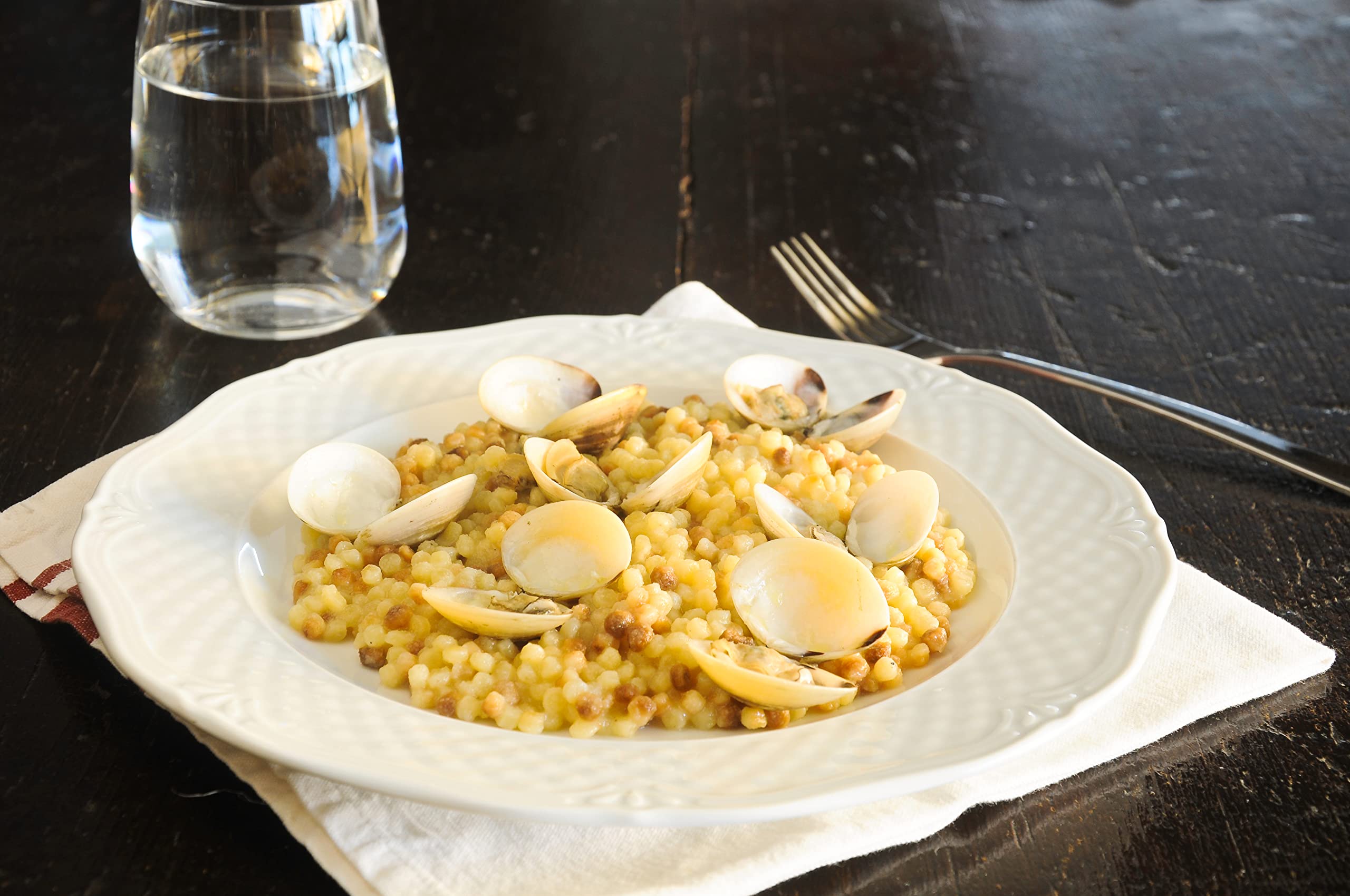 Sanniti fregola texture on spoon showcasing toasted surface and bite