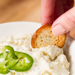 Schwartz Brothers Bakery hand holding a chip to show scale and sturdy crispness benefit