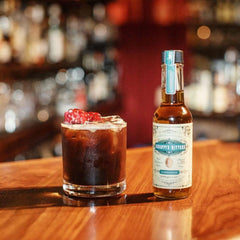 Hand holding Scrappy's cardamom bottle to show scale and easy bar use