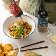 Seed + Mill squeeze bottle pouring spicy tahini over bowl for easy portioning