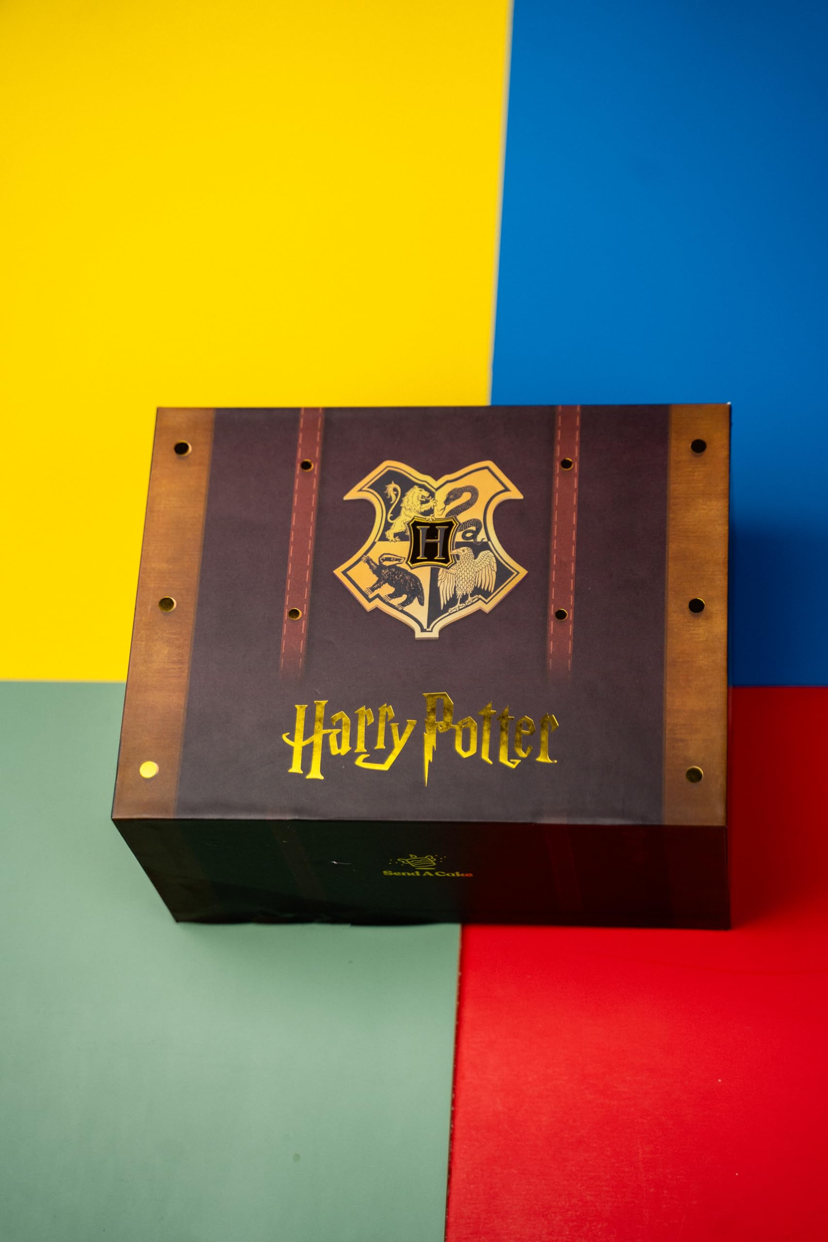 Send A Cake box held by hand for scale showing compact, gift-ready size