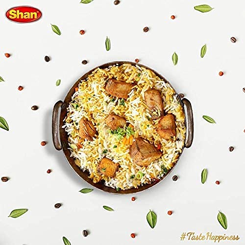 Shan masala sprinkled into a hot skillet delivering immediate fragrance