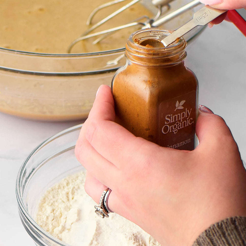 Simply Organic jar held beside a measuring spoon demonstrating compact 2.45‑ounce size