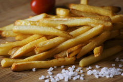 Hand tearing a Single Serv packet and sprinkling salt, precise portion control
