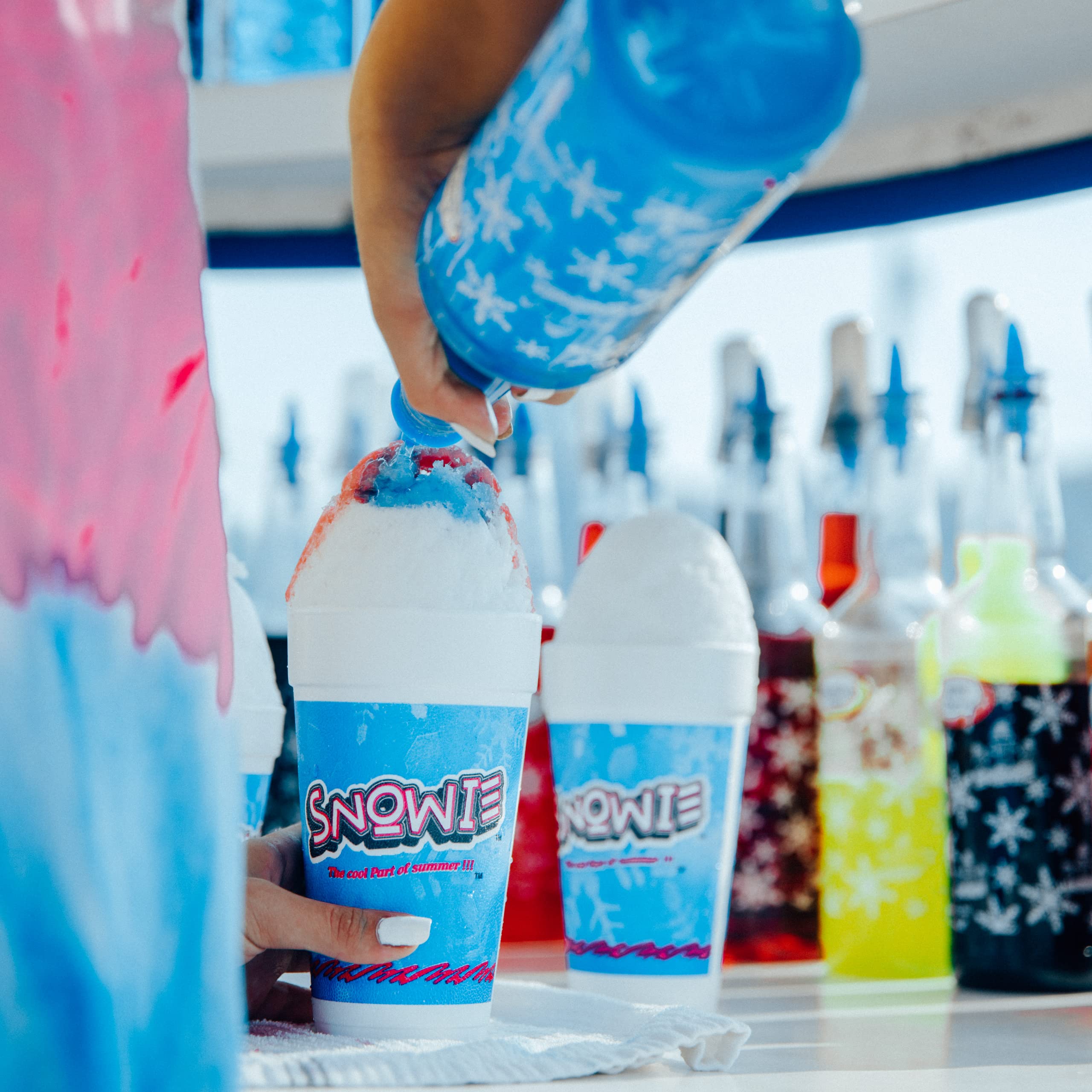 SNOWIE blue raspberry syrup on shaved ice showcasing vibrant color and appeal