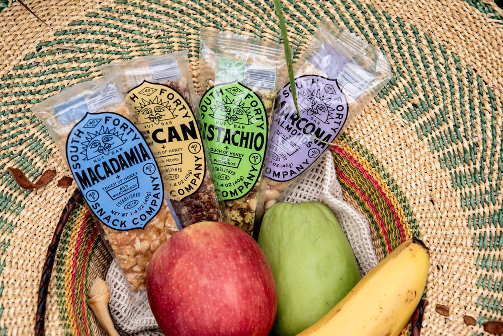 South Forty Snacks bar on a kitchen table with fruit, suggests satisfying snack pairing