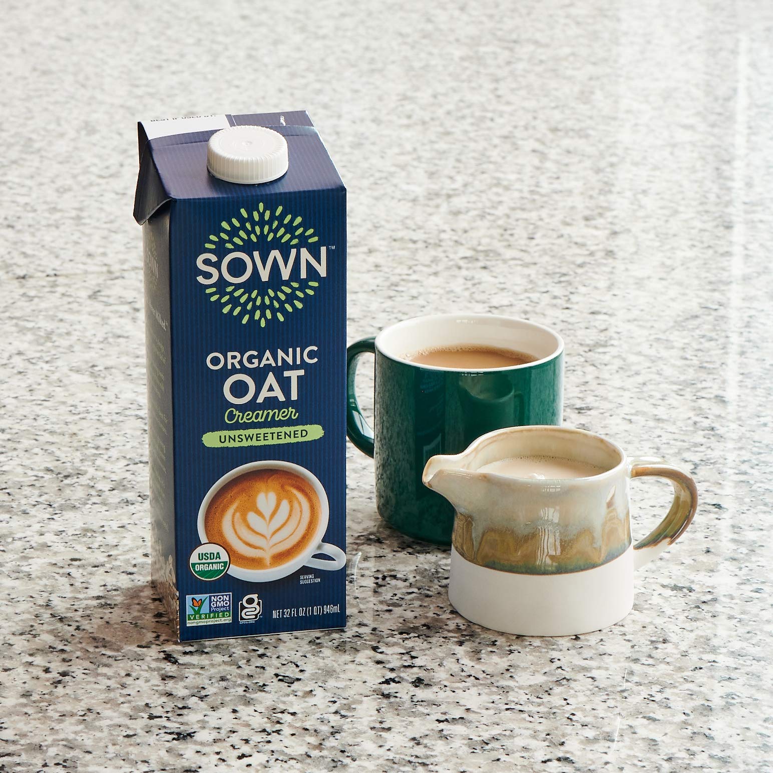 Hand holding a SOWN 32oz carton to show size and portability for home or cafe use