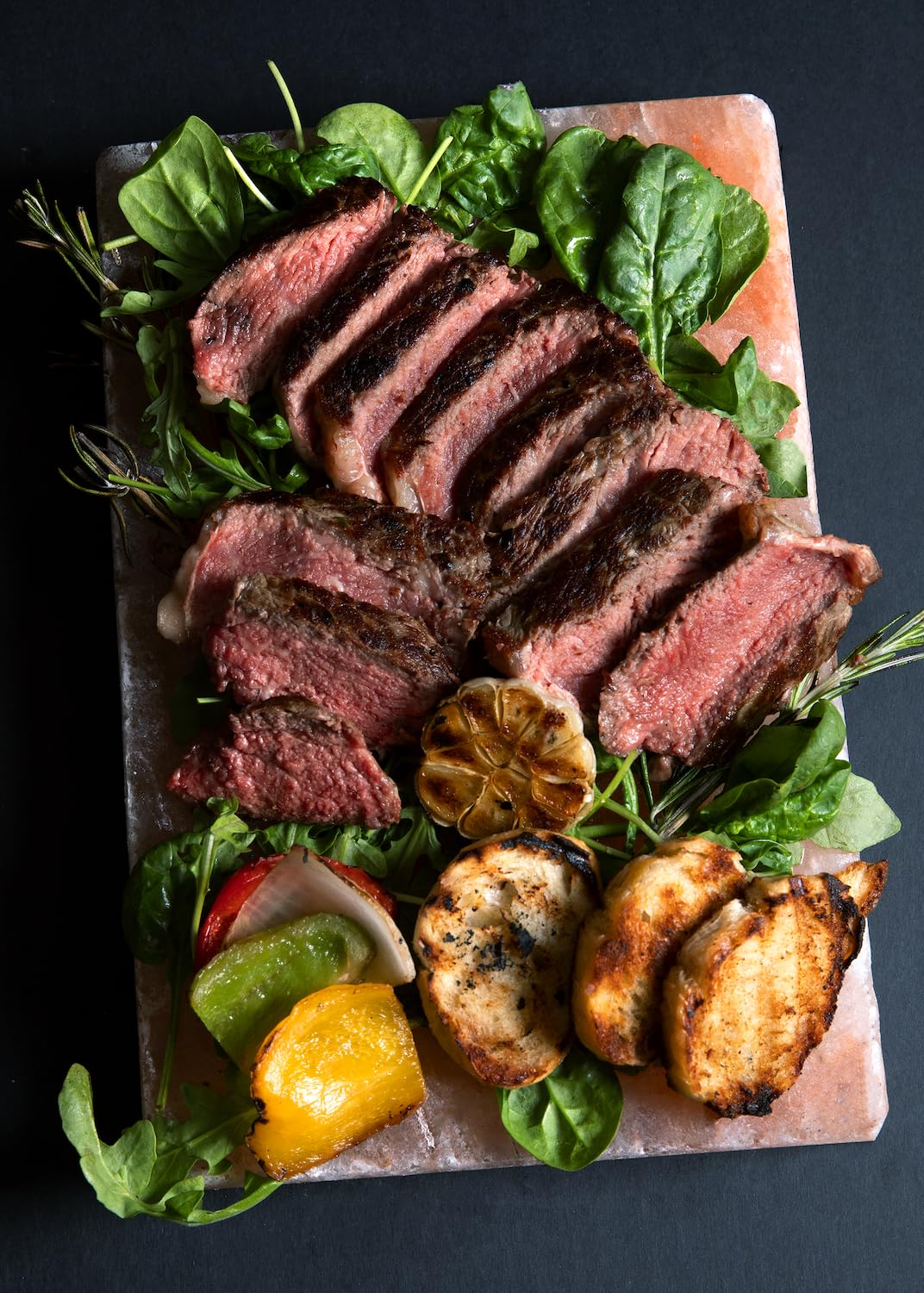 Spantik salt slab serving seared steak and vegetables, presents food attractively