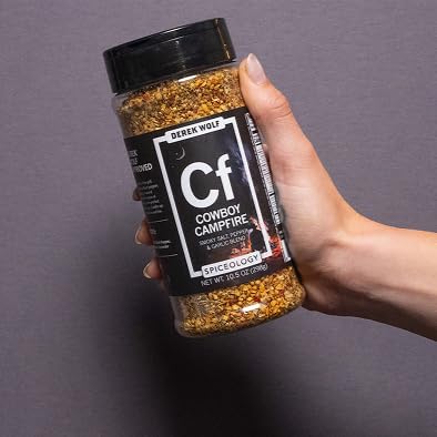 Spiceology jar beside a backyard grill and plated food, suggests easy cookout enhancement