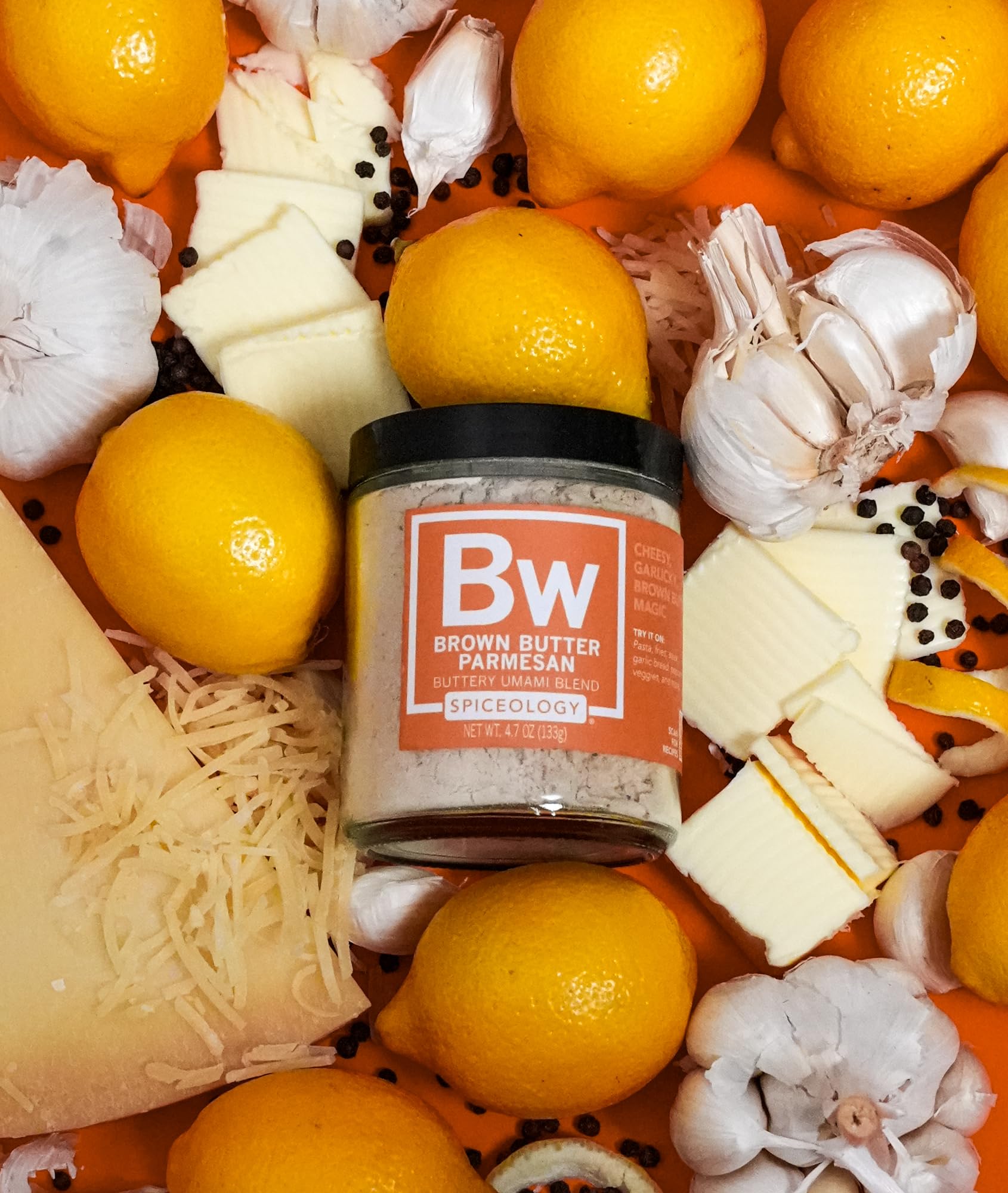 Arranged ingredients—Parmesan, lemon peel, butter granules—Spiceology highlighting real components