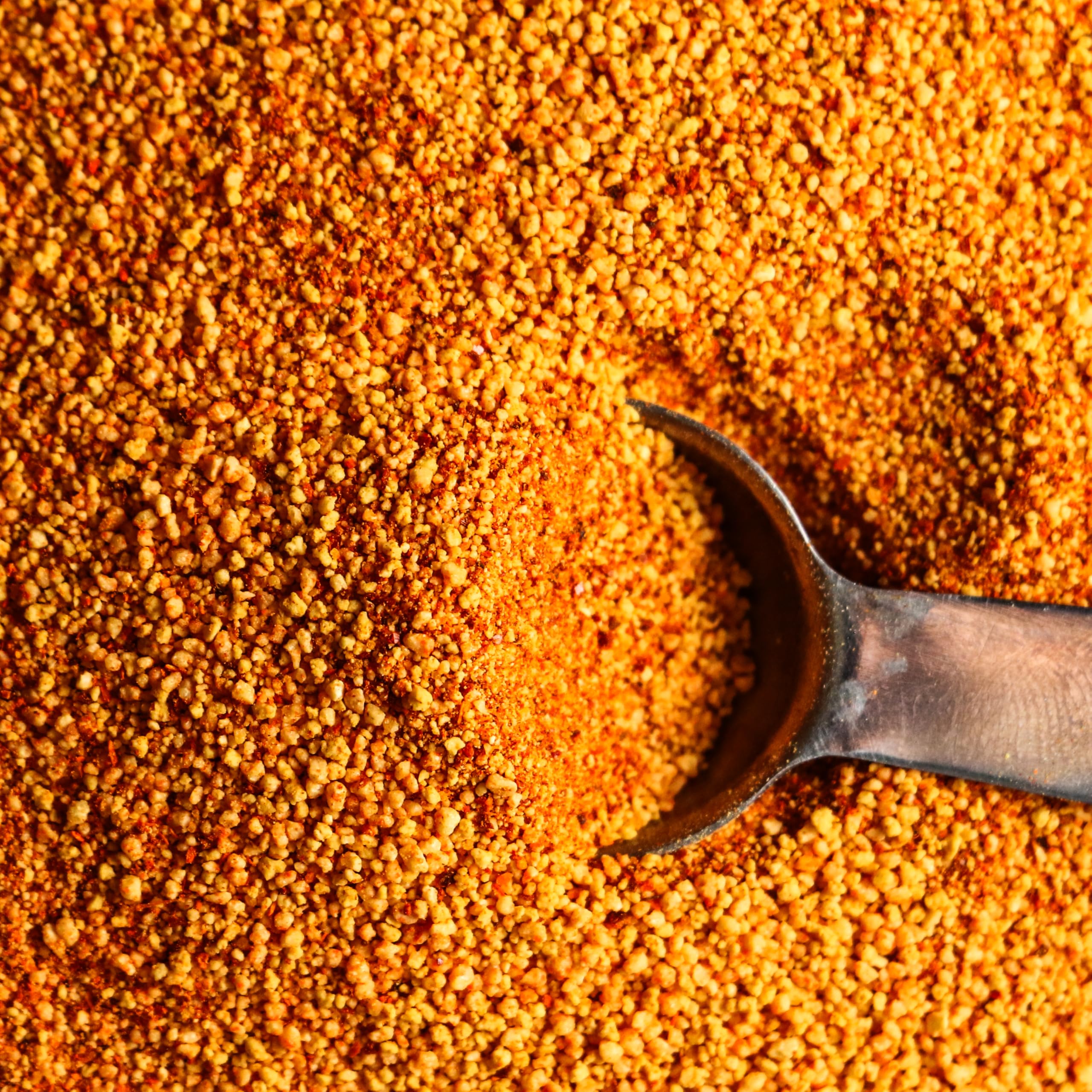 Spiceology rub in use on ribs at a grill delivering caramelized crust and smoky sweet benefit