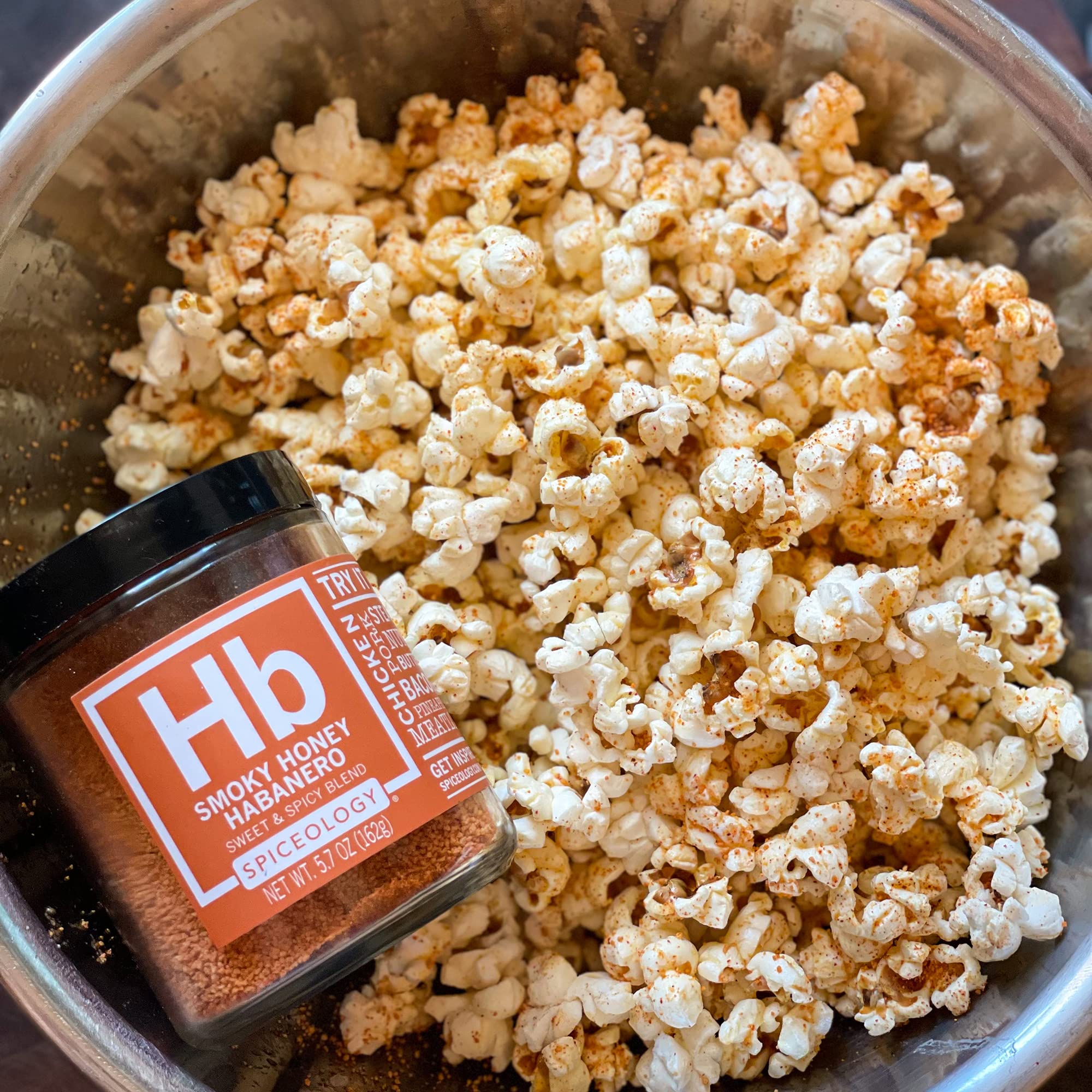Hand holding the 5.7 oz Spiceology jar to show practical serving size