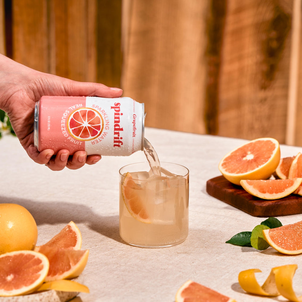 Spindrift grapefruit being poured into a glass showing vibrant color and fizzy appeal