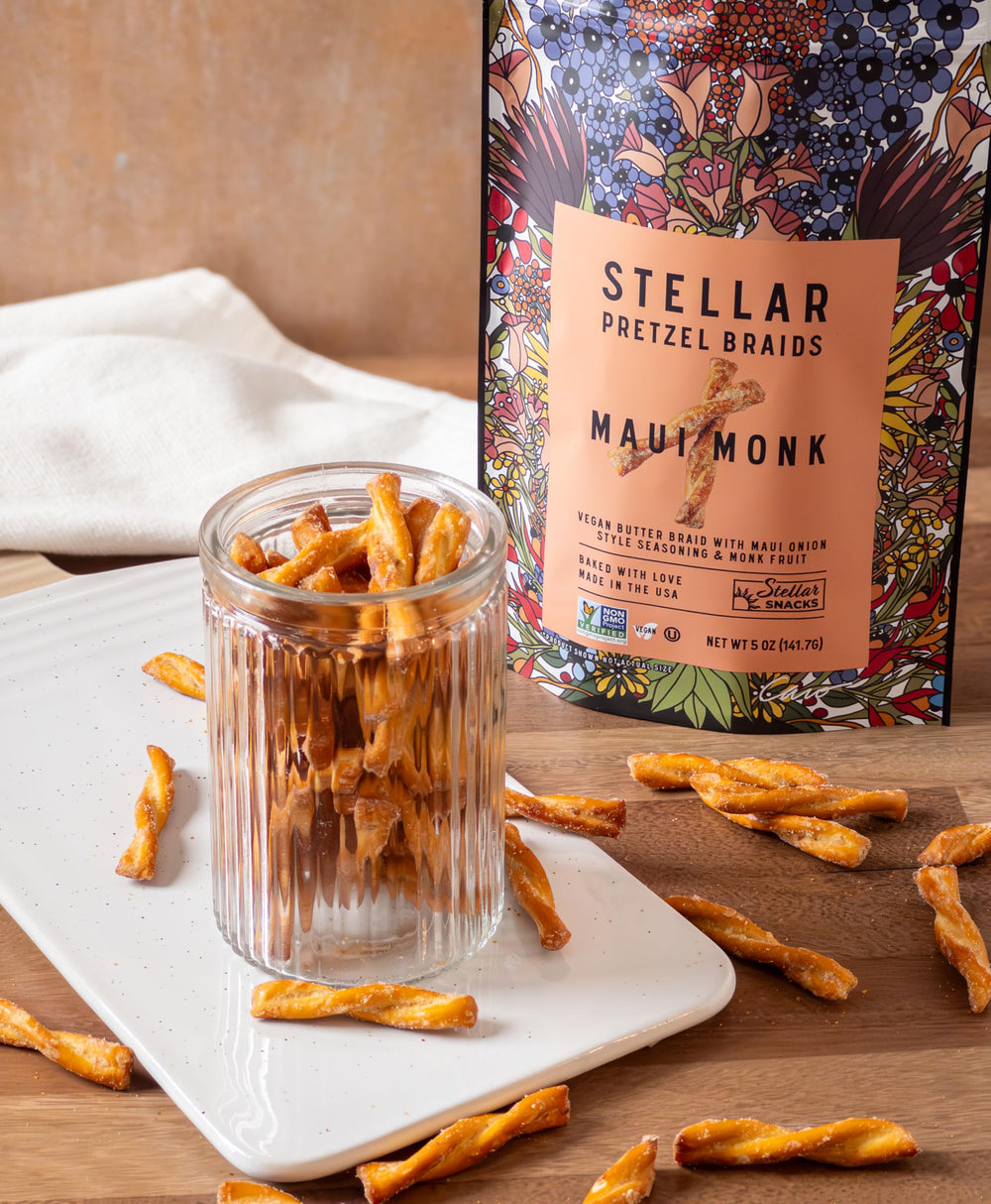 Hand holding a 5 oz Stellar Snacks bag to show true-size scale and easy single-serve use