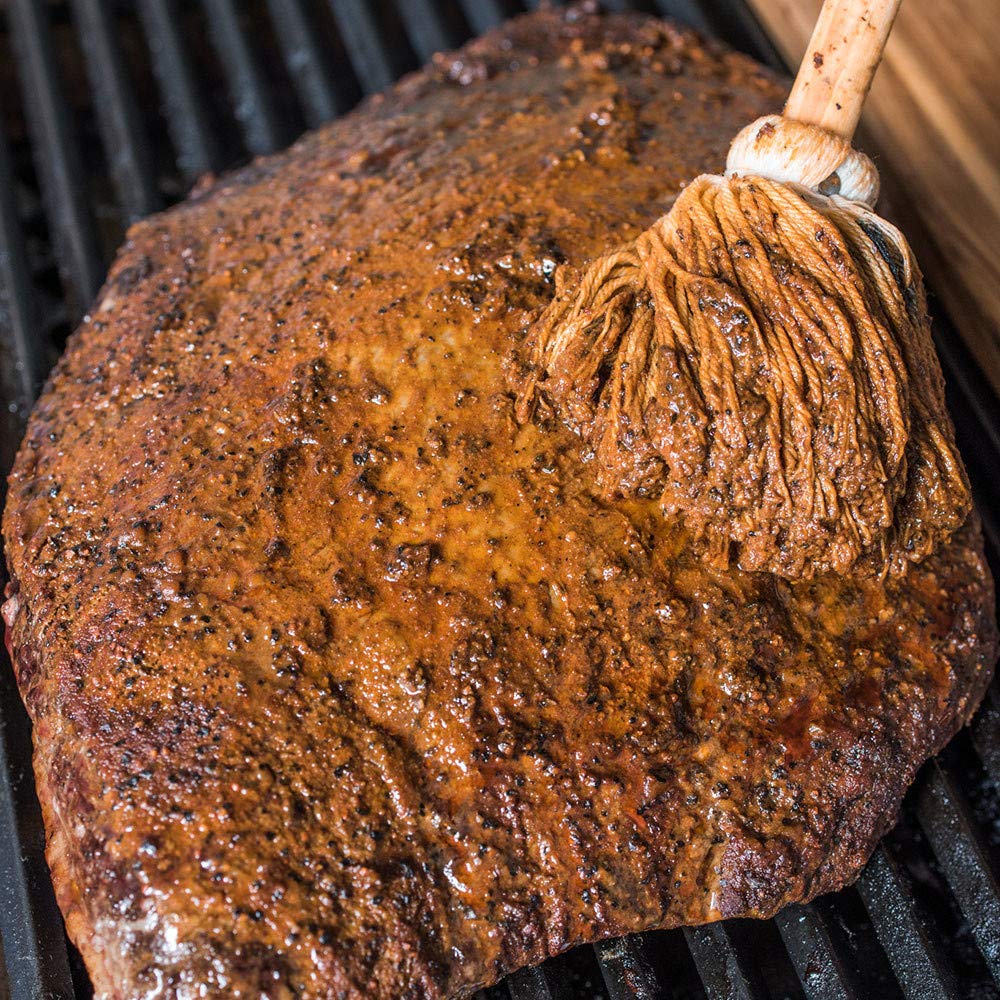 Basting ribs on the grill with Stubb's moppin' sauce to maintain juiciness
