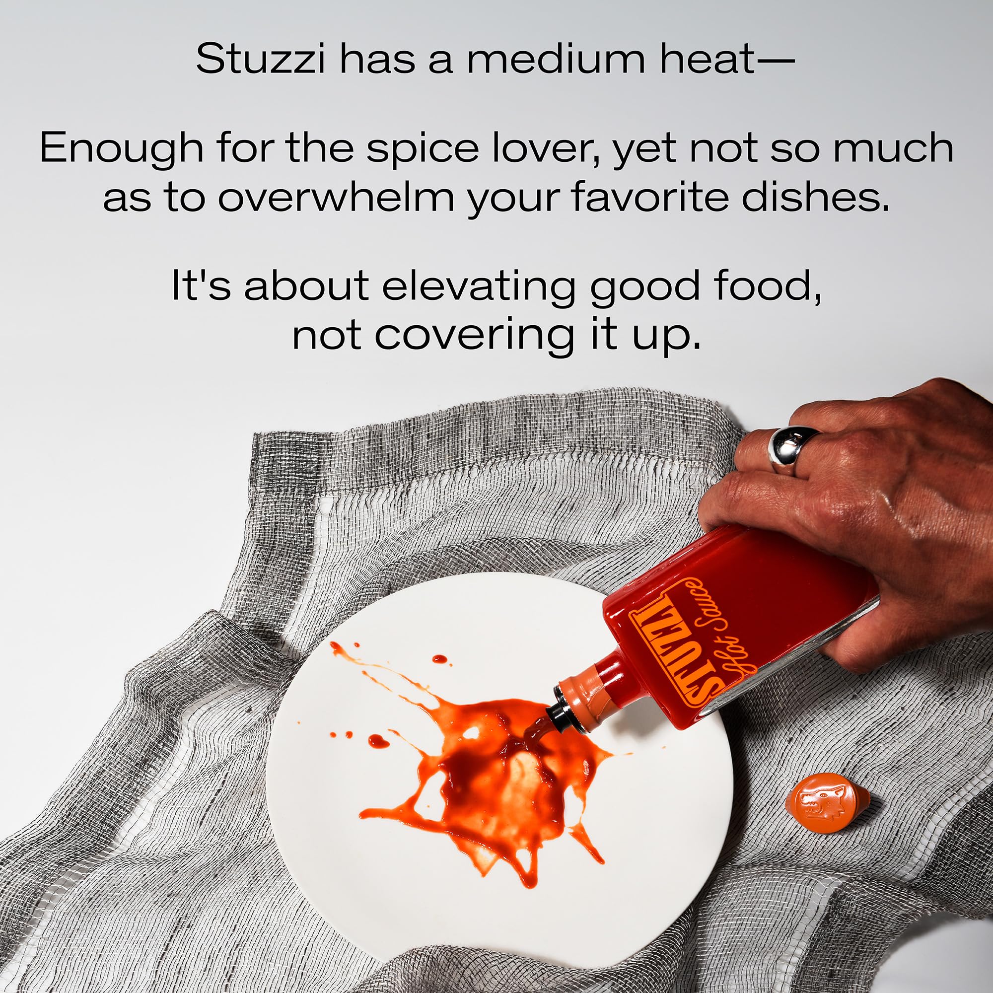 Stuzzi Hot Sauce drizzled on charred vegetables adding savory heat and brightness