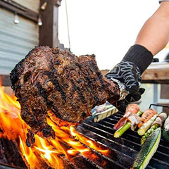 SuckleBusters being sprinkled on a sizzling steak on the grill for bold flavor