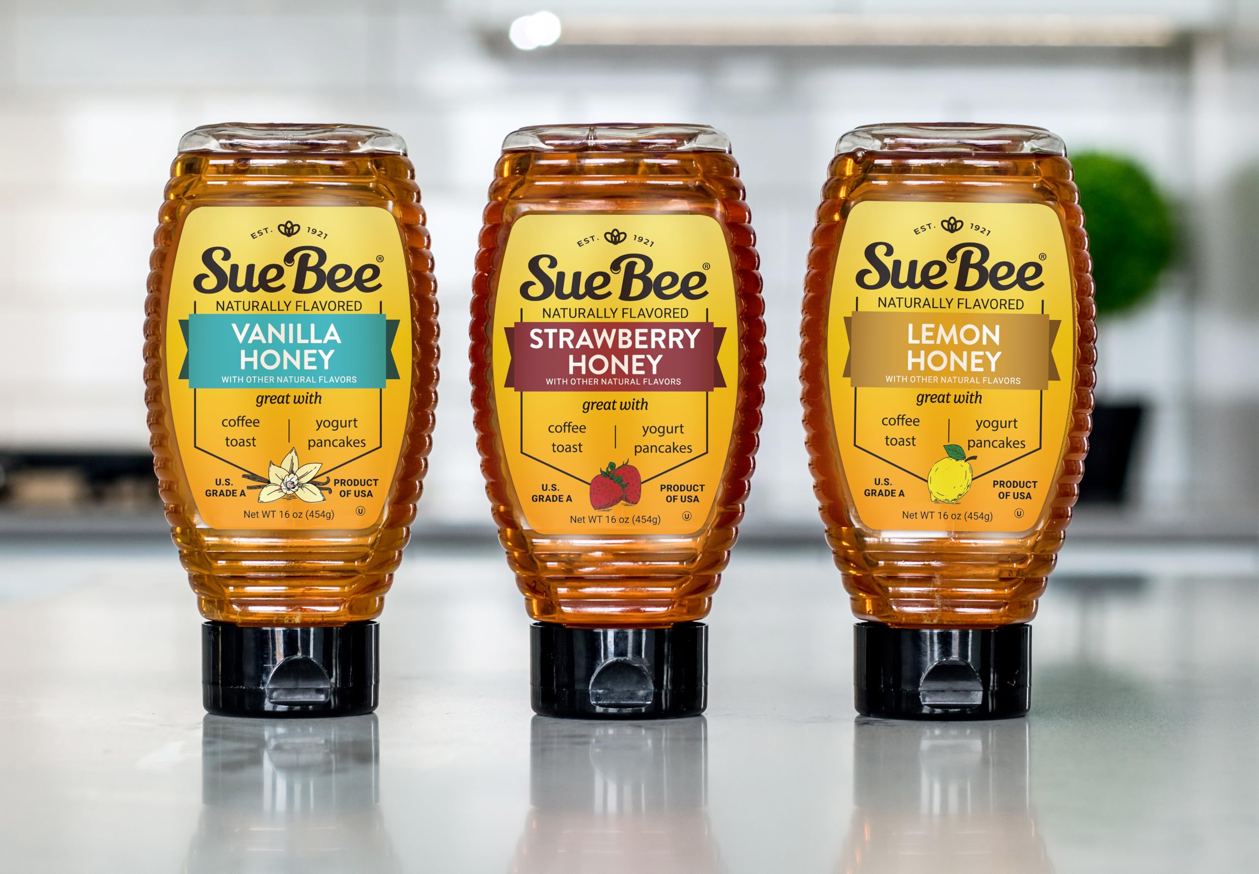 Sue Bee 16 ounce bottle beside a spoon showing actual serving size