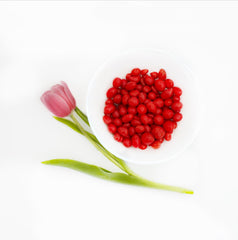 Close-up of SweetGlob candy-coated peanuts highlighting glossy red shell and crunch benefit