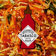 TABASCO sriracha packet being squeezed onto noodles for quick flavor