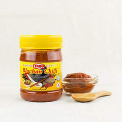 Taho bottle beside a 6.3 oz scale and hand for size, clarifies 180g portion