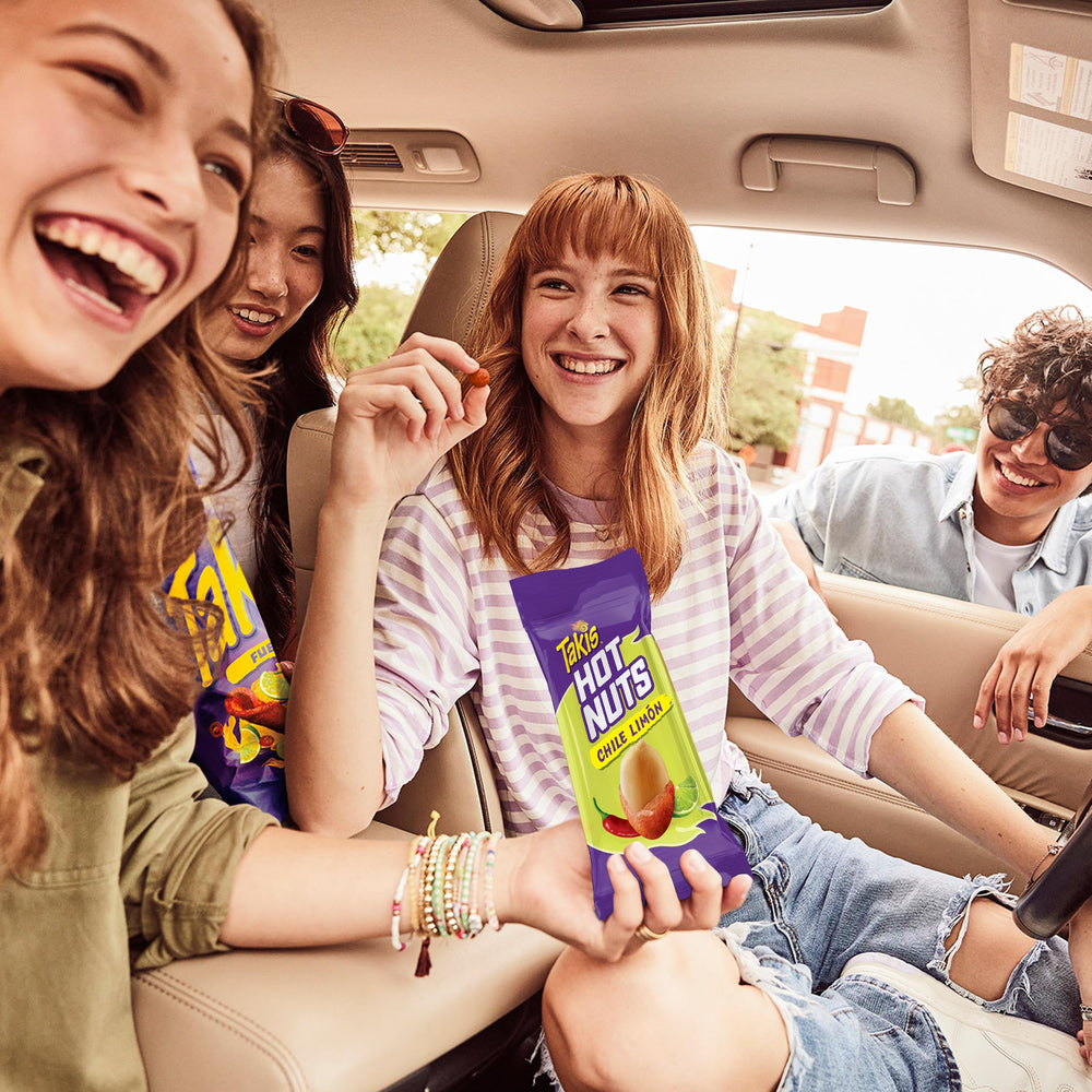 Hand holding Takis Flare snack bag while snacking, convenient on-the-go enjoyment